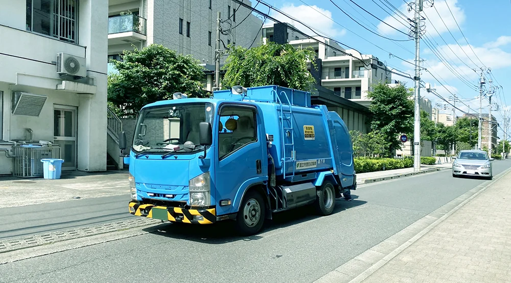 住宅街の道路を走るごみ収集車
